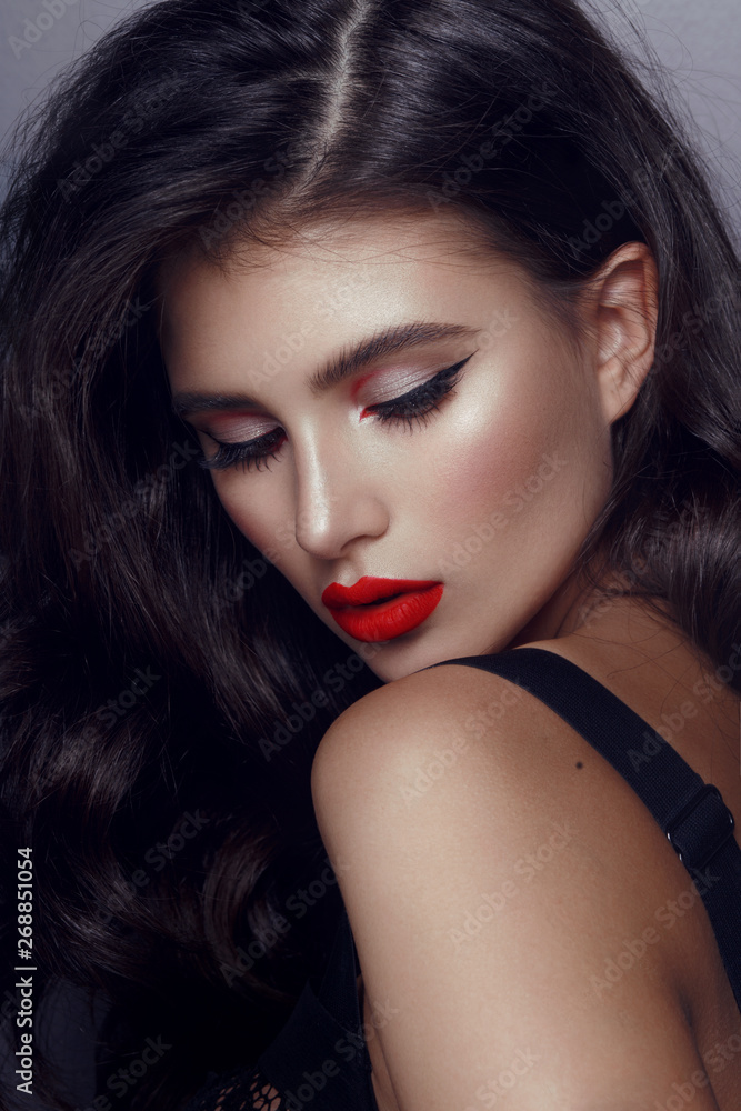Fototapeta premium Closeup portrait of beautiful woman with bright elegant make-up. Sexy young woman with red lipstick and black long hair.