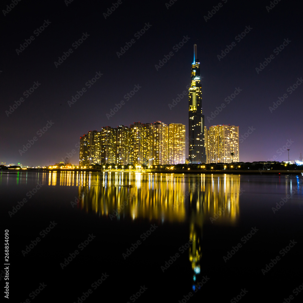 Ho Chi Minh City, Vietnam - May 7, 2019 : Riverside City at nightclouds in the sky at end of day brighter coal sparkling skyscrapers along beautiful river in Ho Chi Minh City, Vietnam - Image