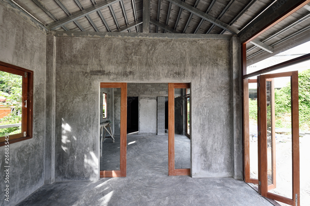 Empty interior of an unfinished concrete and wood home under construction Empty interior of an unfinished concrete and wood home under construction
