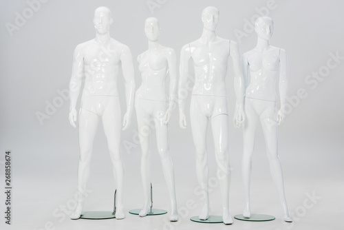 white plastic mannequins in row on grey photo
