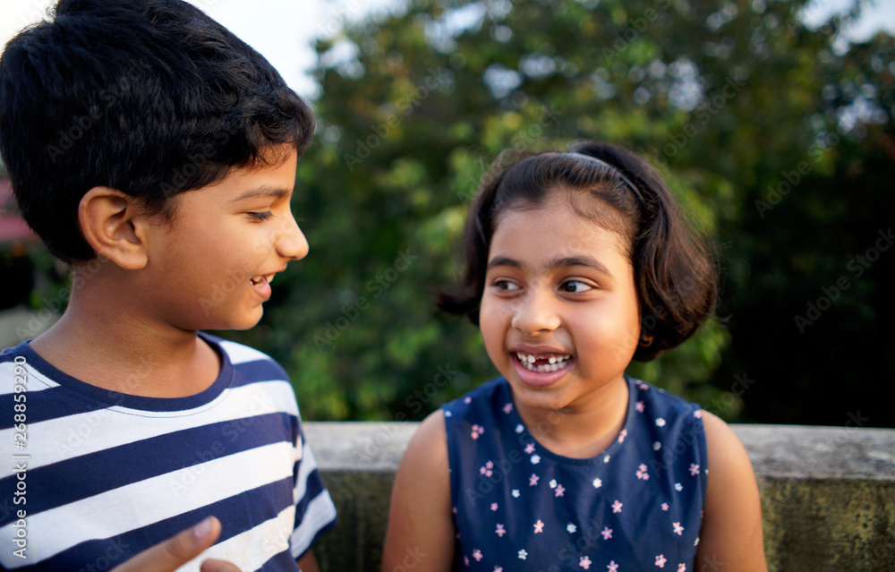 Young boy sharing a secret with his younger sister,having fun Stock