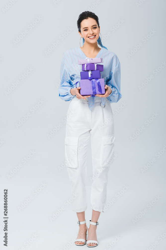 beautiful stylish girl holding gift boxes and smiling on grey beautiful stylish girl holding gift boxes and smiling on grey