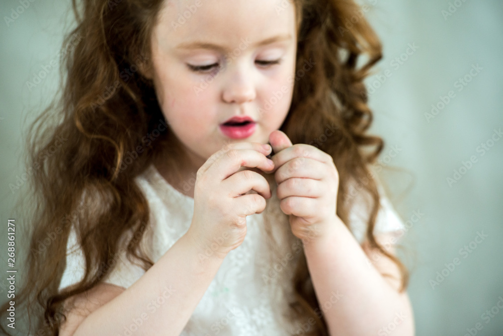 A little girl learns to use colorful play dough. Close-up. A little girl learns to use colorful play dough. Close-up.
