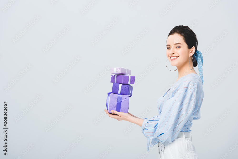 beautiful stylish girl holding gift boxes and smiling isolated on grey beautiful stylish girl holding gift boxes and smiling isolated on grey