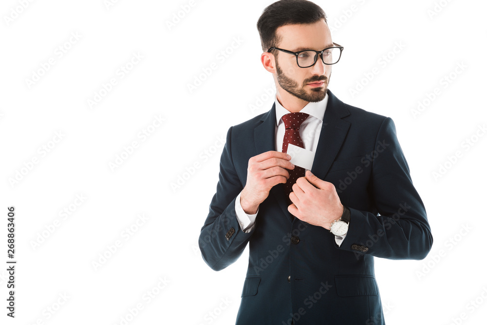 serious businessman getting business card out of jacket and looking away isolated on white