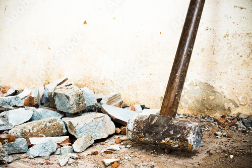 A hammer used to demolish the concrete tile floor and wall of the house before renovation. It heavy and very hard because it made from metal.