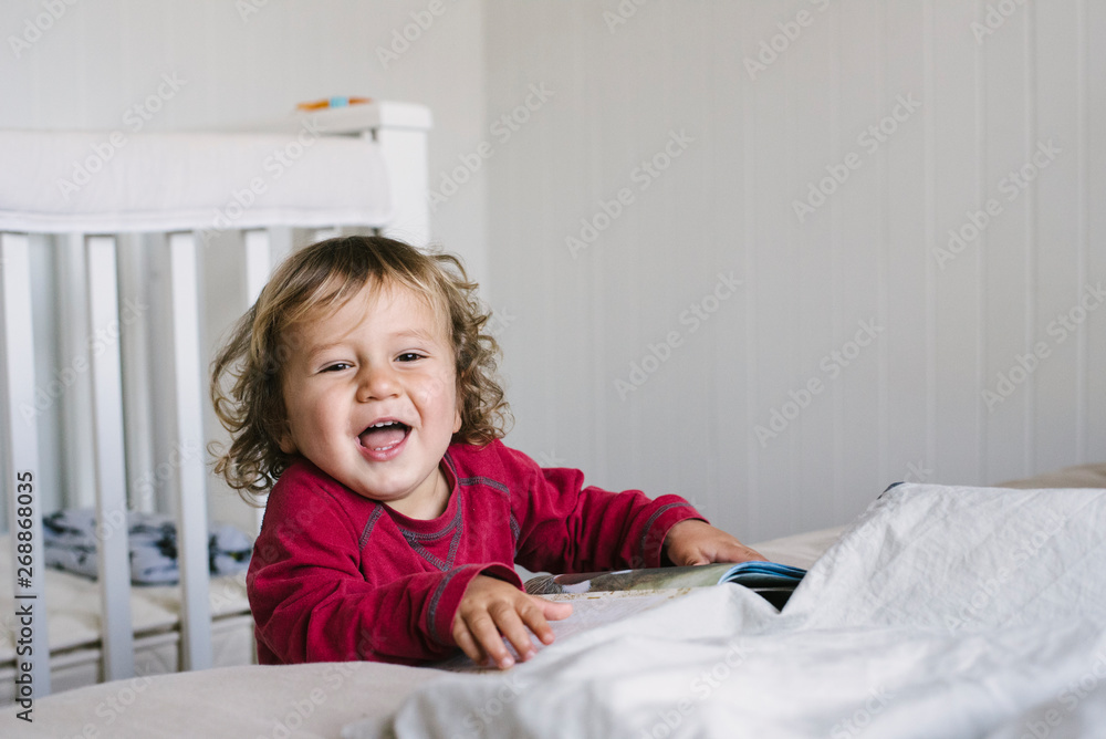 Toddler boy smiling at camera, in bedroom. New Zealand. Toddler boy smiling at camera, in bedroom. New Zealand.