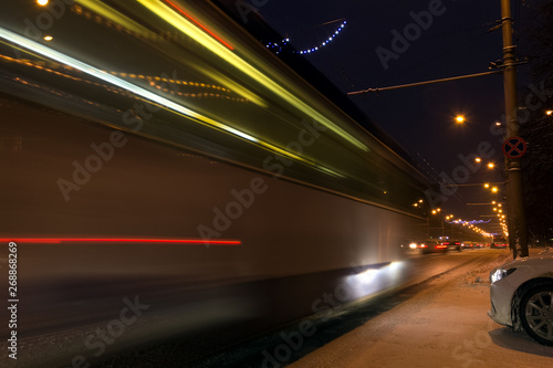 trains of fast passing cars at night on city streets.