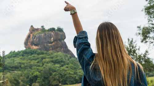 Blonde girl traveller in front of Sigiriya Lion's Rock in Sri Lanka