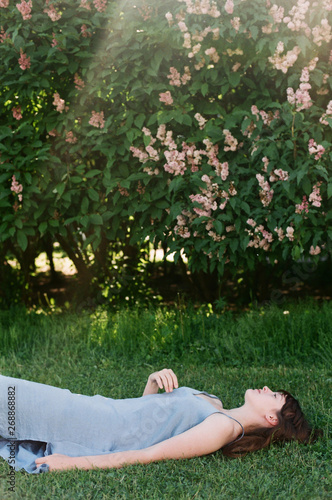 Atmospheric portrait of a woman lying on a grass