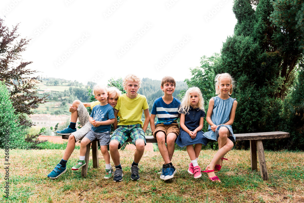 six children sitting on a bench six children sitting on a bench