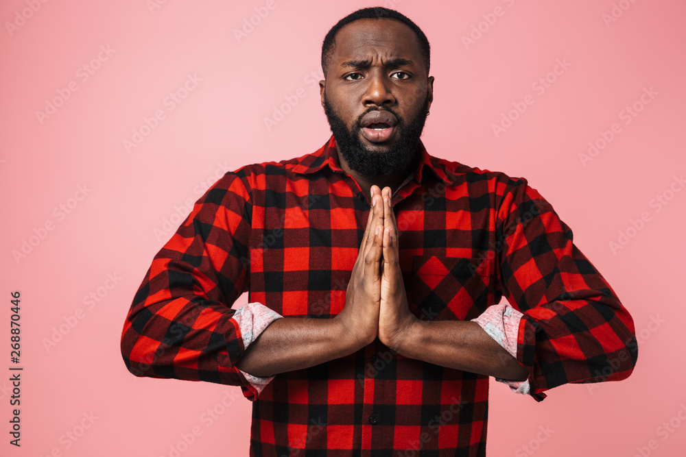 Portrait of a worried african man wearing plaid shirt Portrait of a worried african man wearing plaid shirt