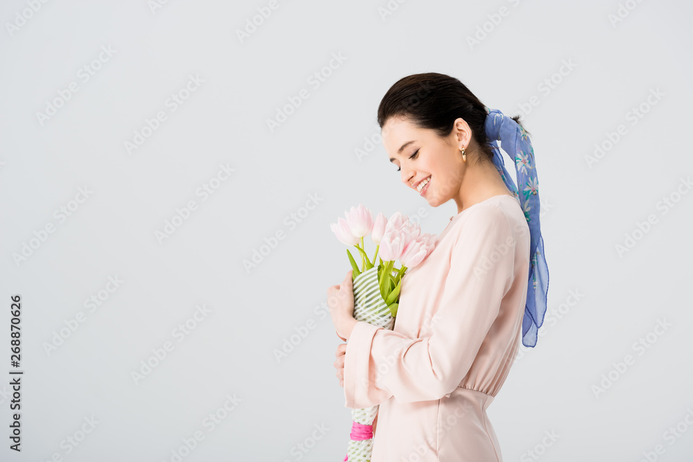 beautiful girl with bouquet of tulips smiling isolated on grey with copy space beautiful girl with bouquet of tulips smiling isolated on grey with copy space