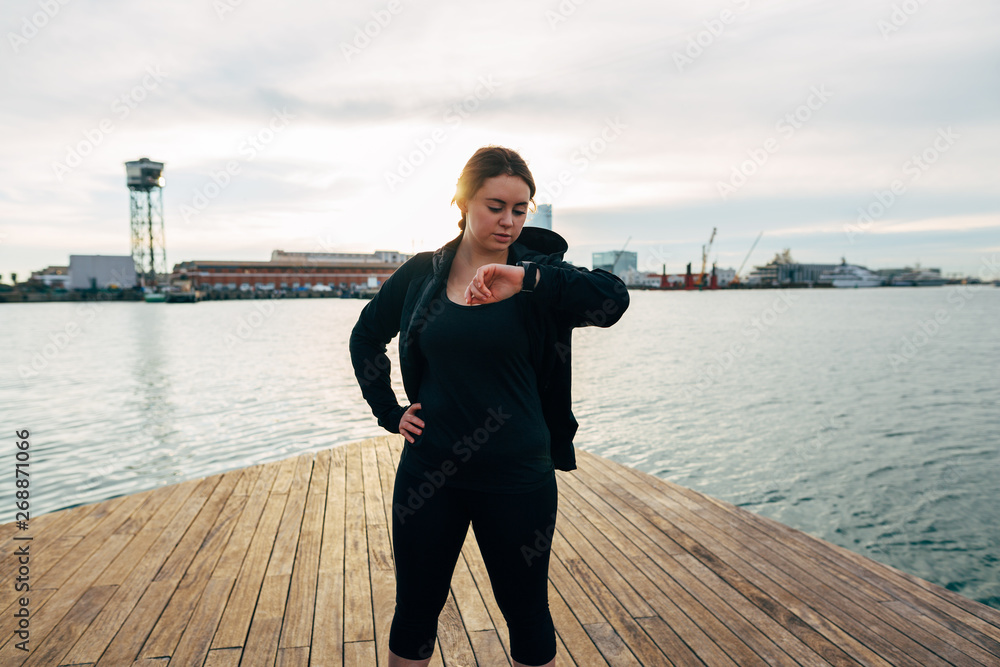 Plus size woman ready to run by seaside. Plus size woman ready to run by seaside.