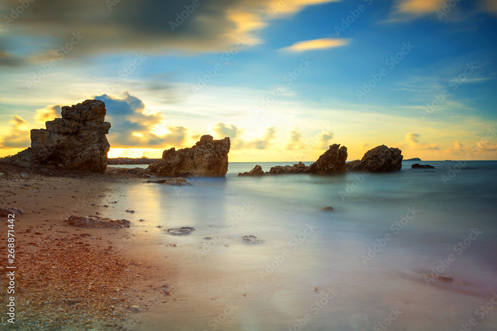 seascape with natural stone arch at sunrise