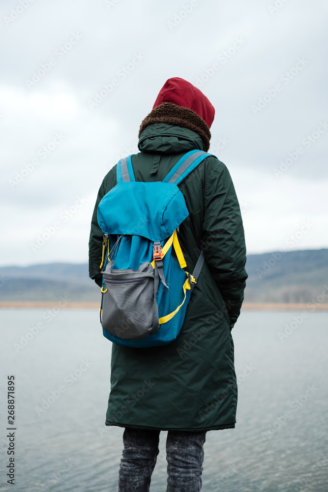 Young man from the back look at the calm lake Young man from the back look at the calm lake