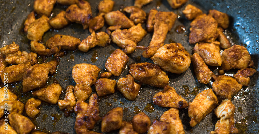 Seasoned pieces of fried chicken on a pan Seasoned pieces of fried chicken on a pan