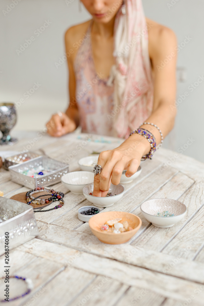 the girl is engaged in needlework from natural stones and beads the girl is engaged in needlework from natural stones and beads