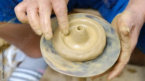 The woman is making a clay bowl.