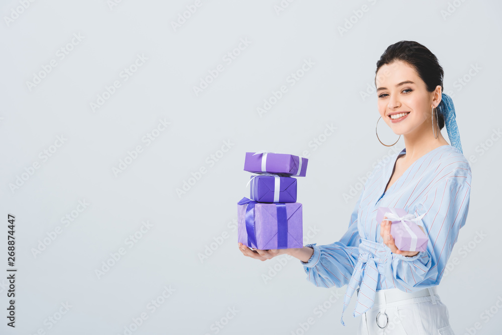 beautiful stylish girl holding gift boxes and smiling isolated on grey beautiful stylish girl holding gift boxes and smiling isolated on grey