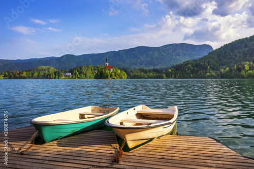 Iconic Bled scenery. Traditional wooden boats Pletna at lake Bled, Slovenia, Europe. Wooden boats with Pilgrimage Church of the Assumption of Maria on the Island on Lake Bled, Slovenia