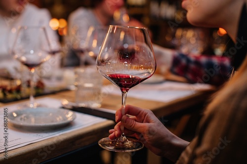 Closeup shot of unrecognizable female holding glass of red wine