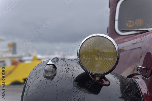 auto d'epoca di colore rosso e nero con gocce di pioggia sulla carozzeria