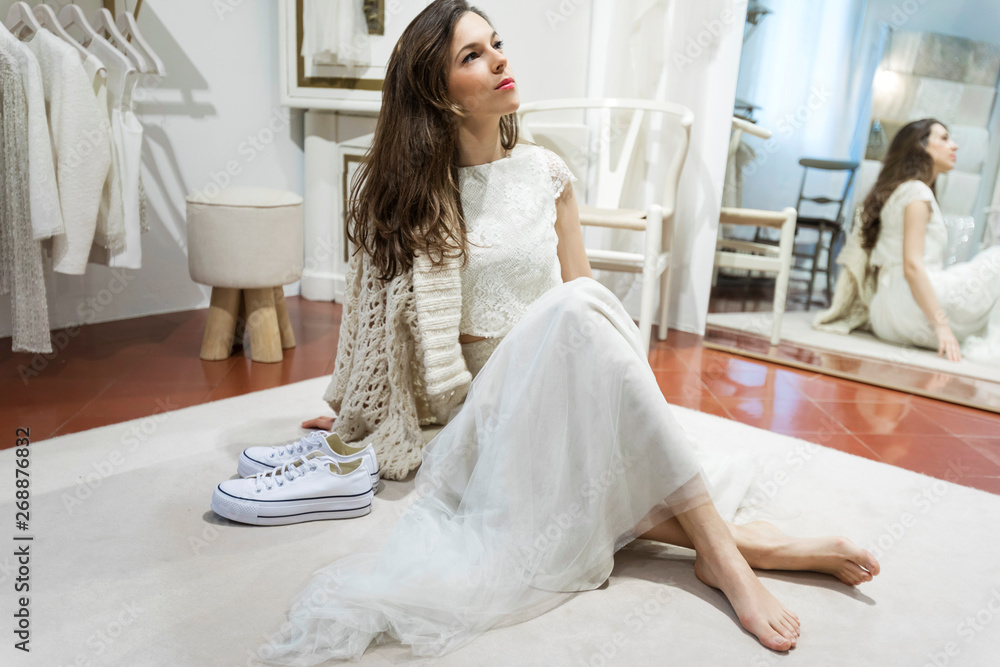 beautiful girl dressed in bridal dress while sitting on floor near mirror beautiful girl dressed in bridal dress while sitting on floor near mirror