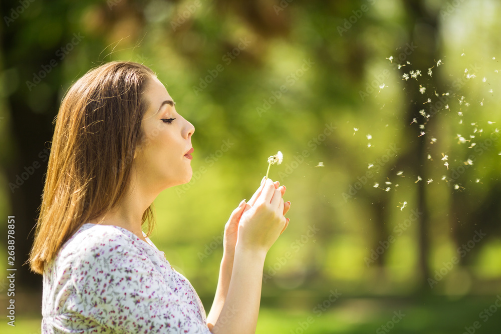 Beautiful young woman blowing dandelion Beautiful young woman blowing dandelion