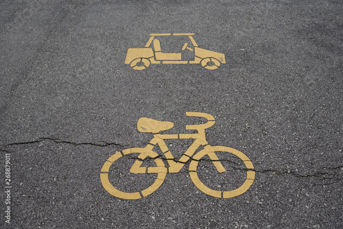 Bicycle and electric car lane sign in yellow on the asphalt. photo