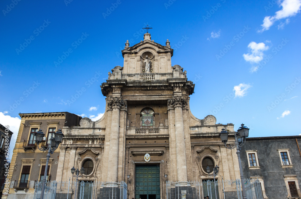 Catania wide view of baroque Carmine basilica facade, side buildings and blue sky Catania wide view of baroque Carmine basilica facade, side buildings and blue sky