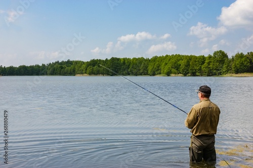 Angler catching the fish in lake 