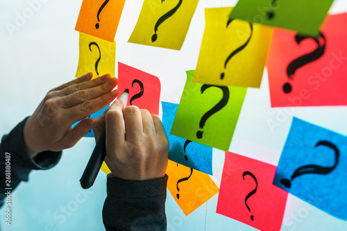 Принти на полотні Businesswoman writing question marks on colorful sticky note paper