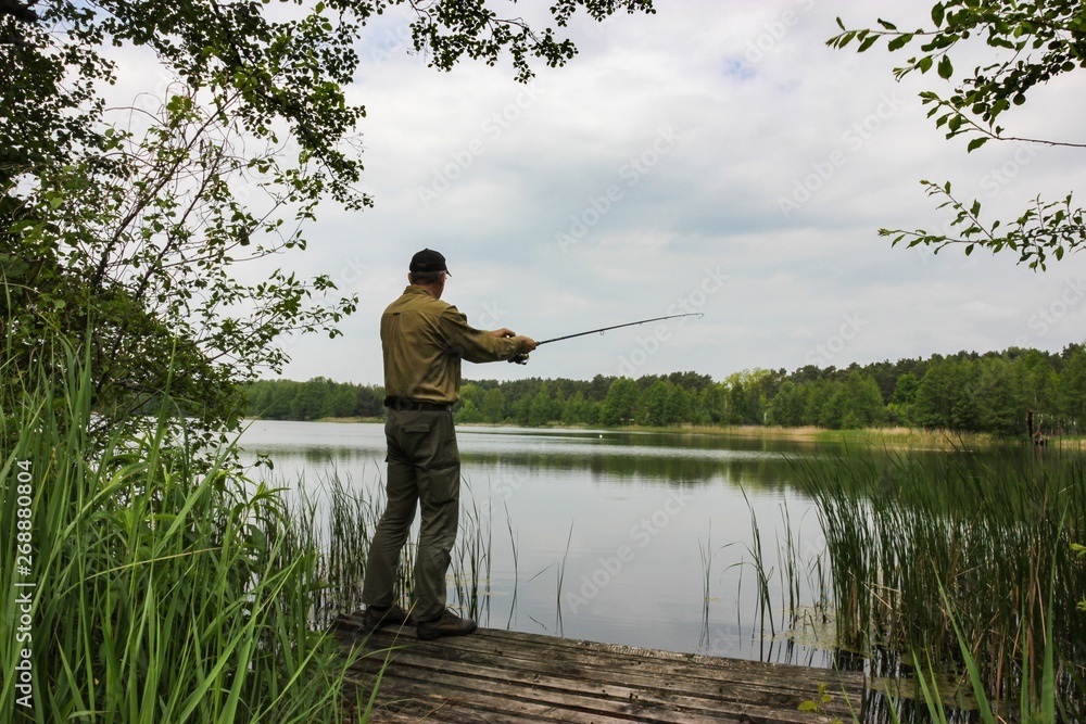 Angler catching the fish in lake Angler catching the fish in lake