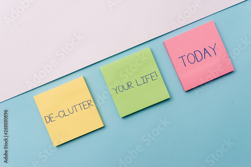 Text sign showing De Clutter Your Life. Business photo showcasing remove unnecessary items from untidy or overcrowded places Pastel colour note papers placed sideways on the of softhued backdrop