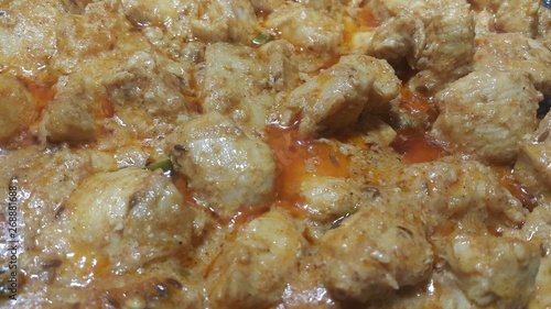 A close up view of stewed chicken meat cubes with spices on it