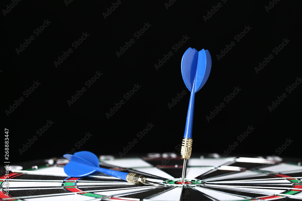 Dartboard with darts on black background Dartboard with darts on black background