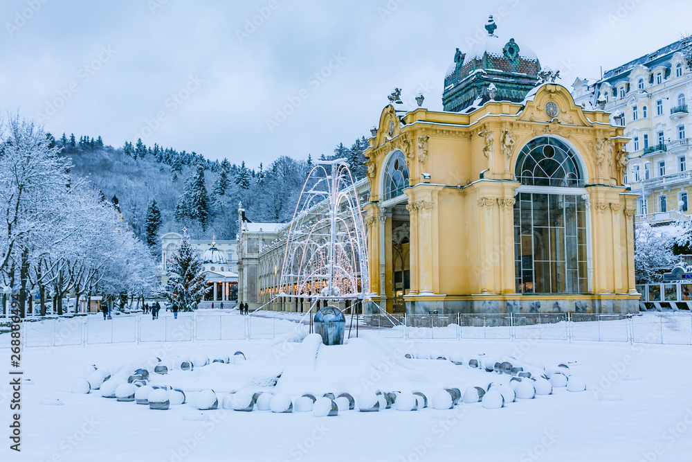 Marianske Lazne, Czech Republic - December 28 2017: Winter image of Colonnade made of cast iron. Singning water fountain in front, all covered with white snow.