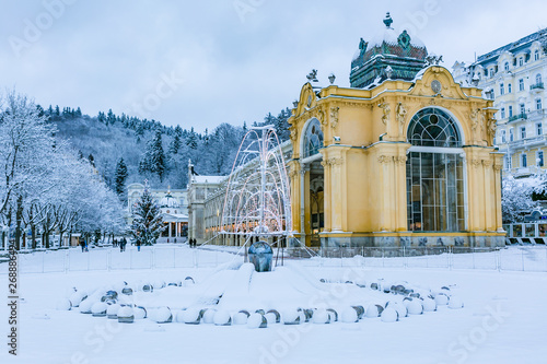 Obraz na płótnie Marianske Lazne, Czech Republic - December 28 2017: Winter image of Colonnade made of cast iron. Singning water fountain in front, all covered with white snow. w salonie