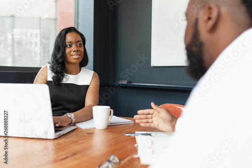 Businesswoman smiles at coworker in meeting