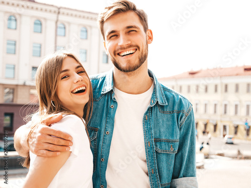 Portrait of smiling beautiful girl and her handsome boyfriend. Woman in casual summer jeans clothes. Happy cheerful family. Female having fun on the street background