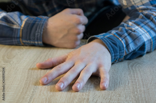 hand of an adult man lying on a wooden table
