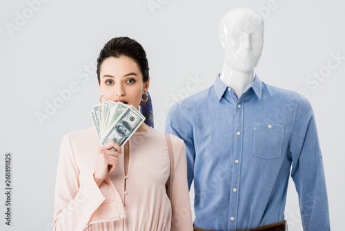 beautiful girl near mannequin holding money isolated on grey