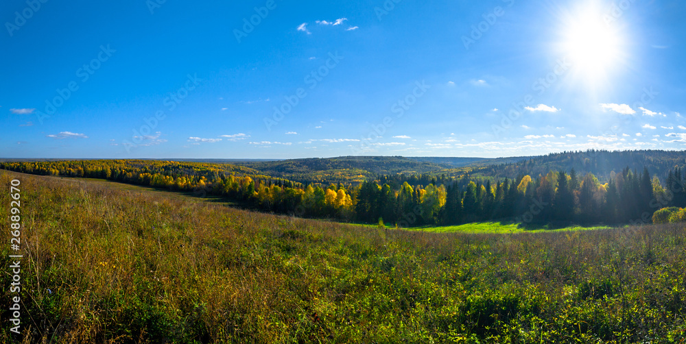 Panoramic view of trees of the autumn wood from above, with blue sky, Stone Hill, Mari El, Russia