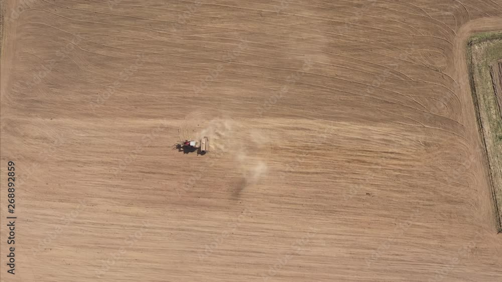 AERIAL: Descending From a Very High Altitude Above Tractor With Seeder Plowing an Empty Field AERIAL: Descending From a Very High Altitude Above Tractor With Seeder Plowing an Empty Field