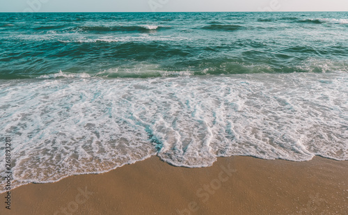 Sea wave and brown sand beach in grey tone. © NPD stock