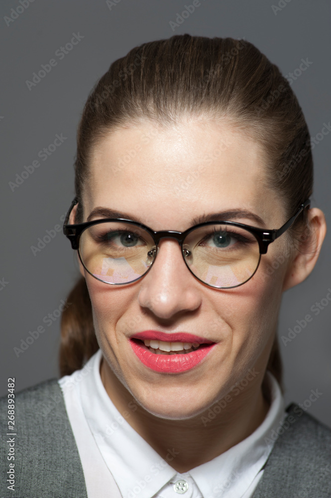 Young beautiful businesswoman or manager in glasses looks at the camera. Young beautiful businesswoman or manager in glasses looks at the camera.
