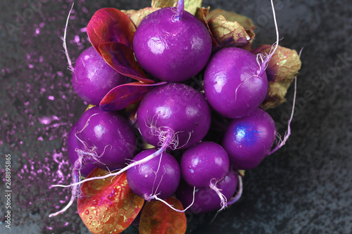 Bright abstract bunch space cosmic alien radioactive infected food purple radish with gold leaves and water drops unnatural colors in the style of pop zine culture. Creative concept