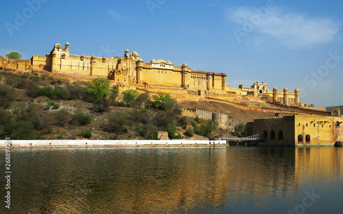 Ancient Amber fort magnificent towering on a rocky hill reflected in the clear waters of the lake. Jaipur, India.