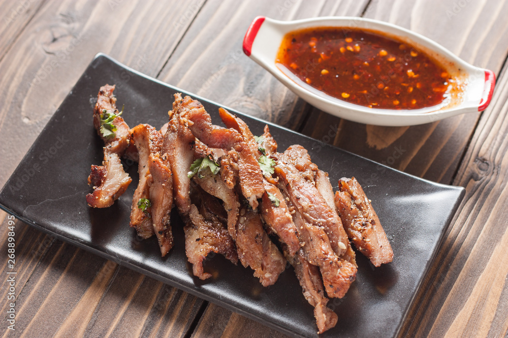 Charcoal-boiled pork neck and sauce on a wooden floor .Grilled Pork thailand style Charcoal-boiled pork neck and sauce on a wooden floor .Grilled Pork thailand style